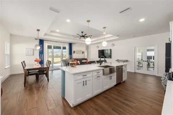 a large white kitchen with lots of counter space dining table and chairs