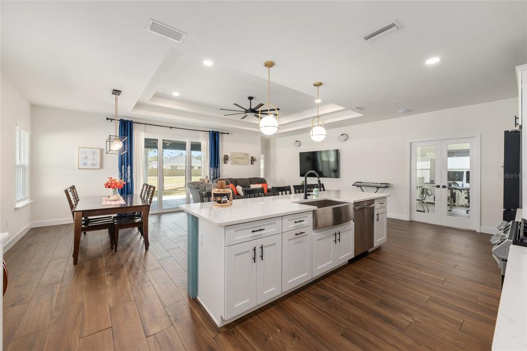 6659 Southwest 12th Lane Gainesville, FL 32607 - Photo 14 of 37 a large white kitchen with lots of counter space dining table and chairs