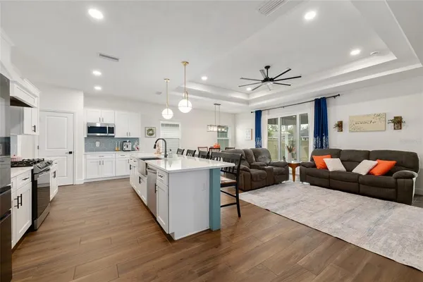 a living room with stainless steel appliances kitchen island furniture and a kitchen view