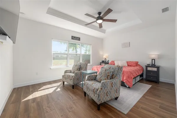 a spacious bedroom with a bed couch and window