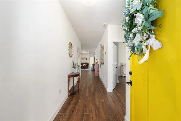 a view of a hallway with wooden floor and a potted plant