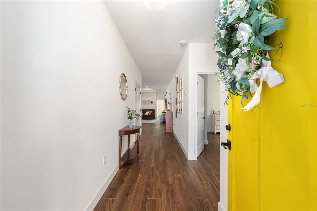 6659 Southwest 12th Lane Gainesville, FL 32607 - Photo 3 of 37 a view of a hallway with wooden floor and a potted plant
