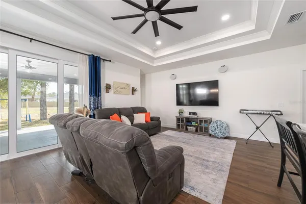 a living room with furniture and a flat screen tv with wooden floor