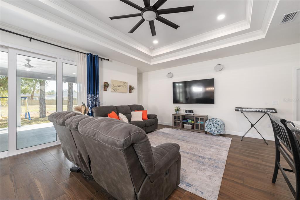 6659 Southwest 12th Lane Gainesville, FL 32607 - Photo 6 of 37 a living room with furniture and a flat screen tv with wooden floor