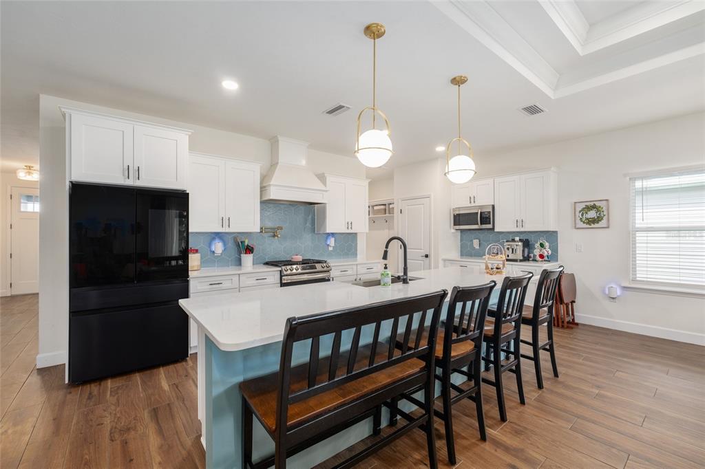 6659 Southwest 12th Lane Gainesville, FL 32607 - Photo 10 of 37 a kitchen with stainless steel appliances a dining table chairs stove refrigerator and cabinets