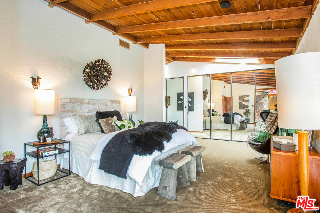 7280 Caverna Drive Los Angeles, CA 90068 - Photo 22 of 30 a bedroom with a bed painting on wall and a large window