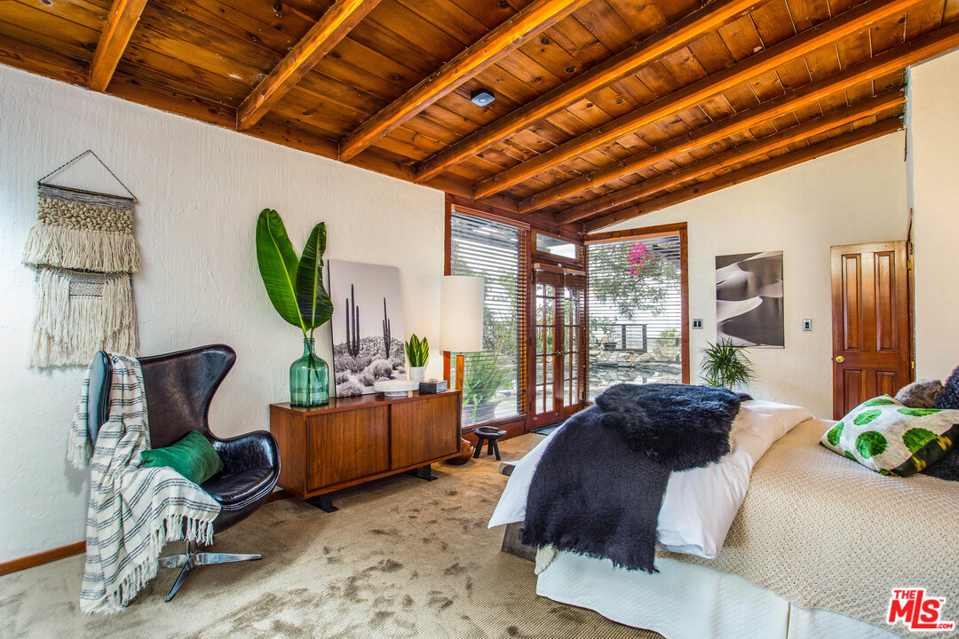 7280 Caverna Drive Los Angeles, CA 90068 - Photo 24 of 30 a spacious bedroom with a bed and a couch