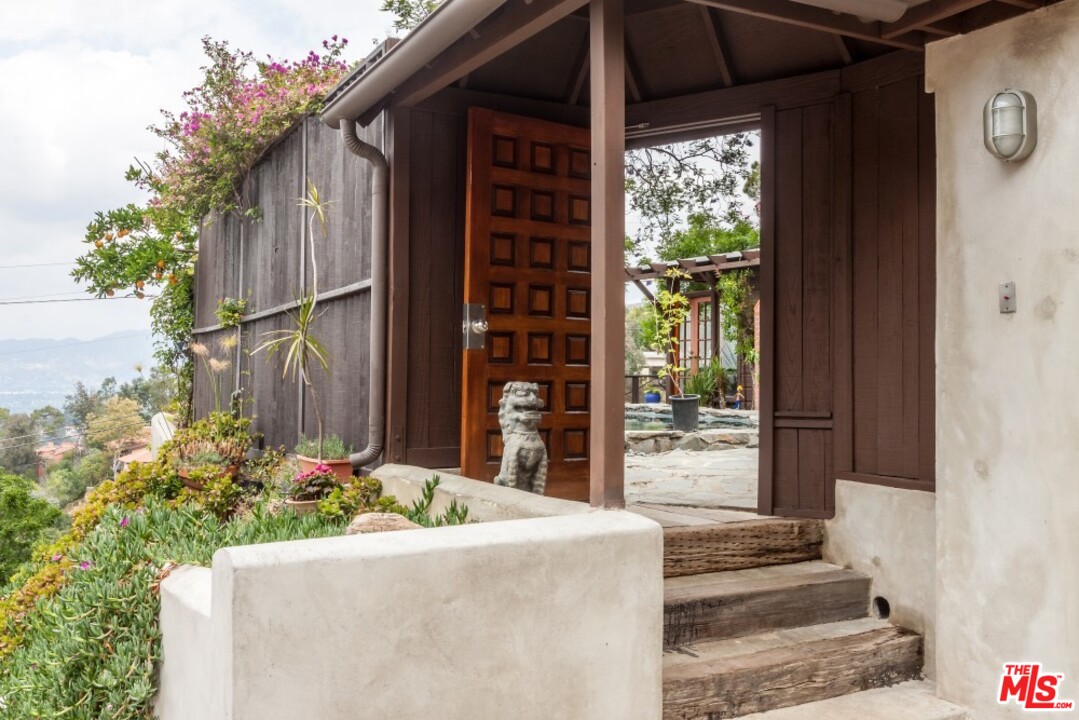 7280 Caverna Drive Los Angeles, CA 90068 - Photo 4 of 30 a front view of a house with a garden