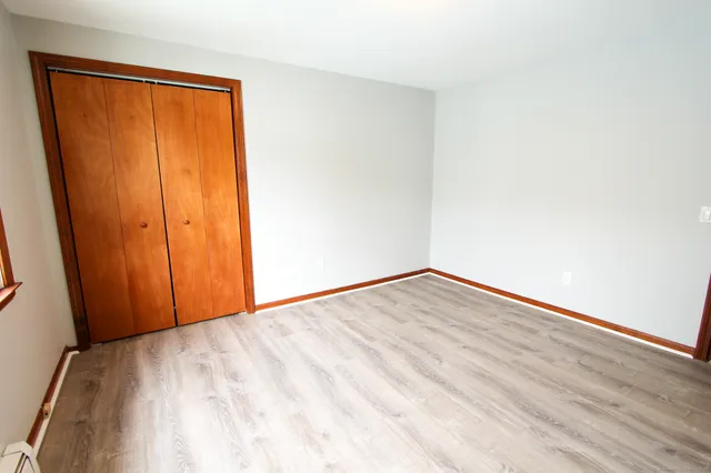 a view of empty room with wooden floor