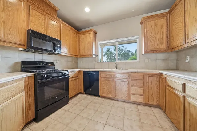 a kitchen with stainless steel appliances granite countertop a sink and cabinets