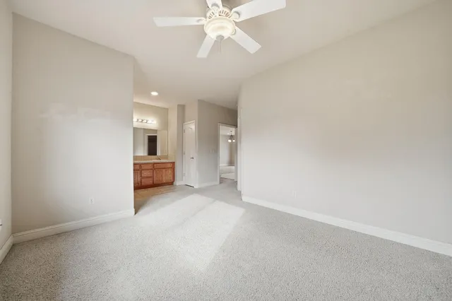 an empty room with chandelier fan and closet area