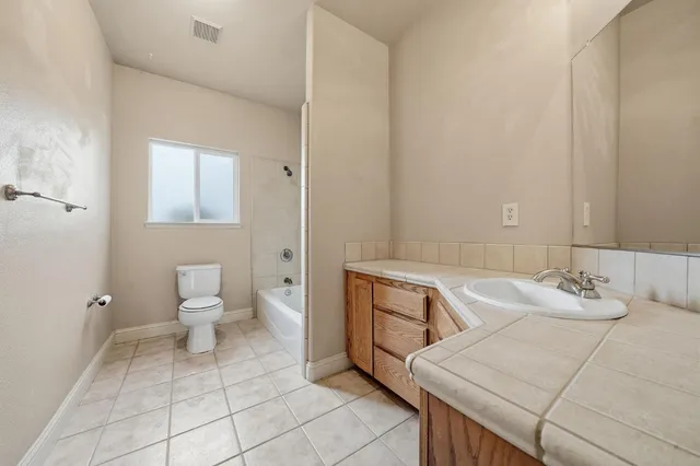 a white toilet sitting next to a bath tub