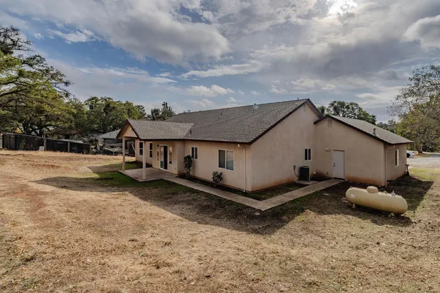a backyard of a house with table and chairs