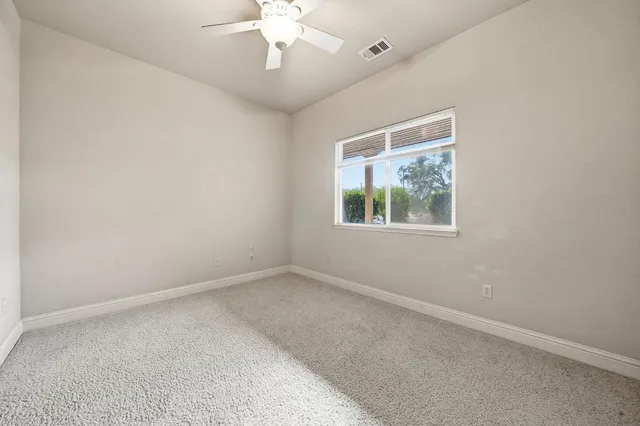 an empty room with a chandelier fan