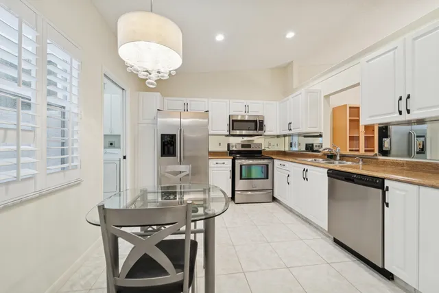 a kitchen with stainless steel appliances kitchen island granite countertop a sink a stove counter space and cabinets