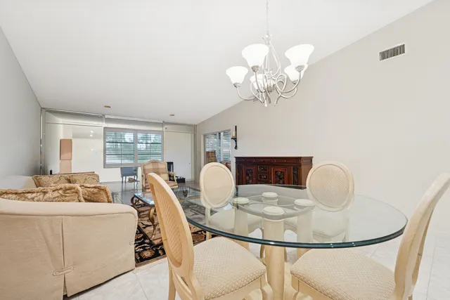 a dining room with furniture a chandelier and window