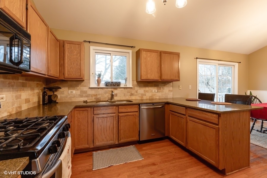 136 Tree Line Antioch, IL 60002 - Photo 4 of 17 a kitchen with stainless steel appliances granite countertop a sink stove and cabinets