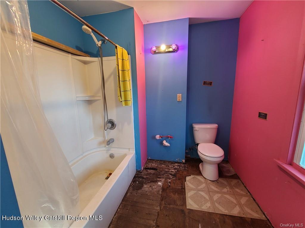 275-277 State Rt 17B Monticello, NY 12701 - Photo 10 of 32 a bathroom with a bathtub shower sink mirror vanity and toilet