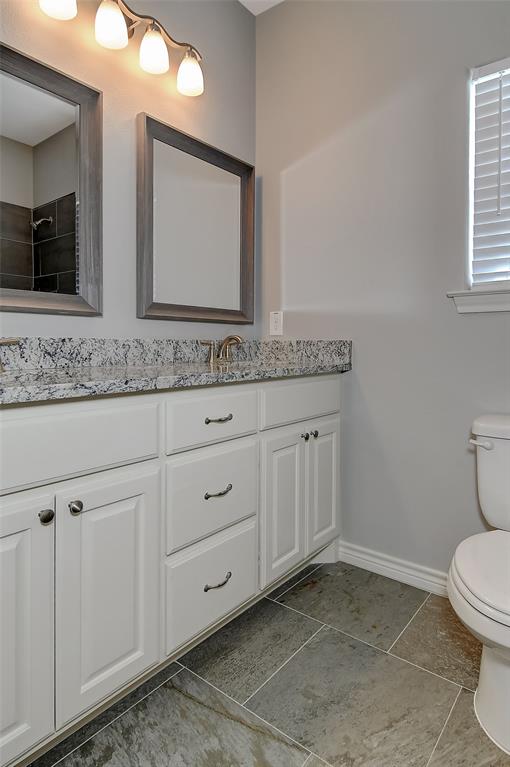 613 East Rosedale Street Sherman, TX 75090 - Photo 15 of 21 a bathroom with a granite countertop toilet sink and mirror