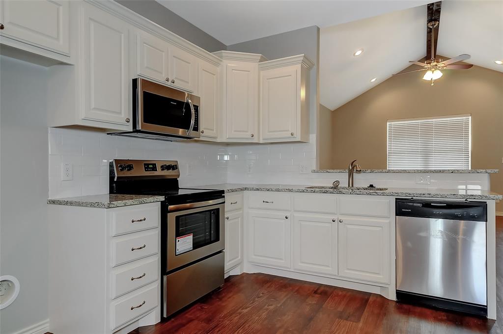 613 East Rosedale Street Sherman, TX 75090 - Photo 7 of 21 a kitchen with granite countertop white cabinets and stainless steel appliances