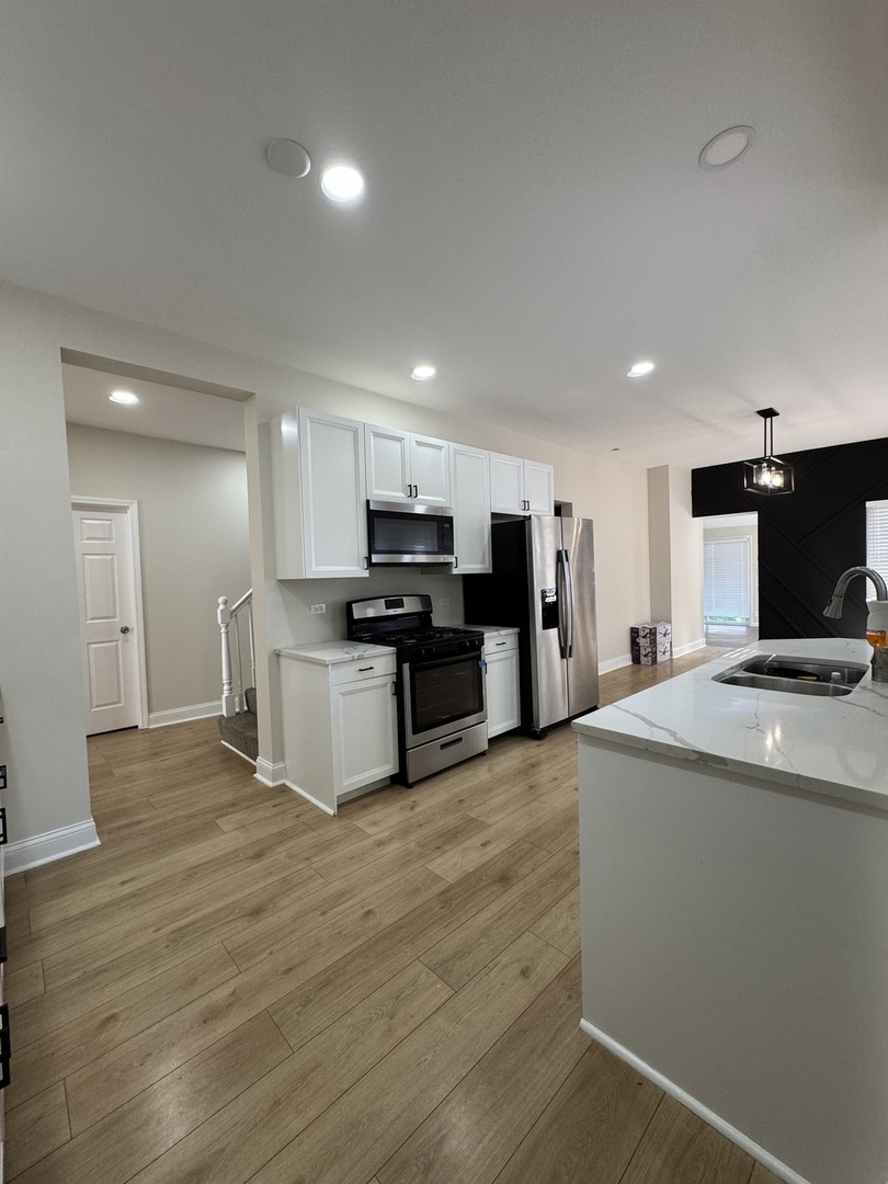 395 Surrey Lane Crete, IL 60417 - Photo 21 of 26 a kitchen with stainless steel appliances kitchen island granite countertop a stove and a refrigerator
