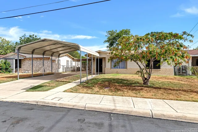 a view of a house with a tree in front of it