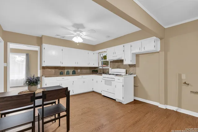 a kitchen with a white cabinets and chairs