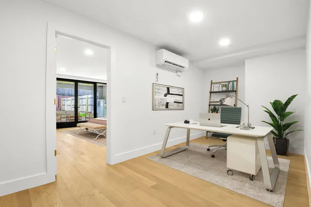 a view of a livingroom with workspace and a window