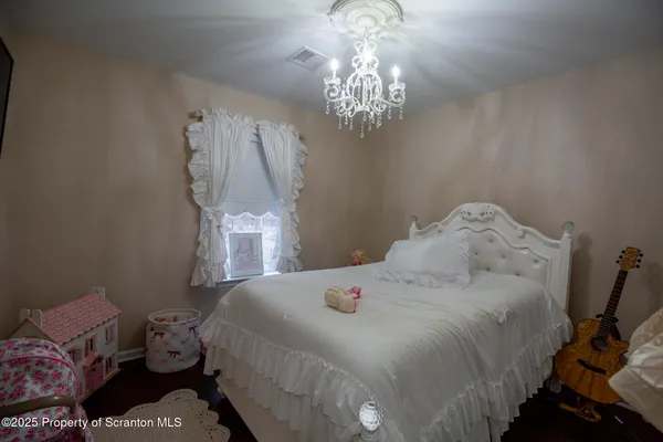a spacious bedroom with a bed and a chandelier