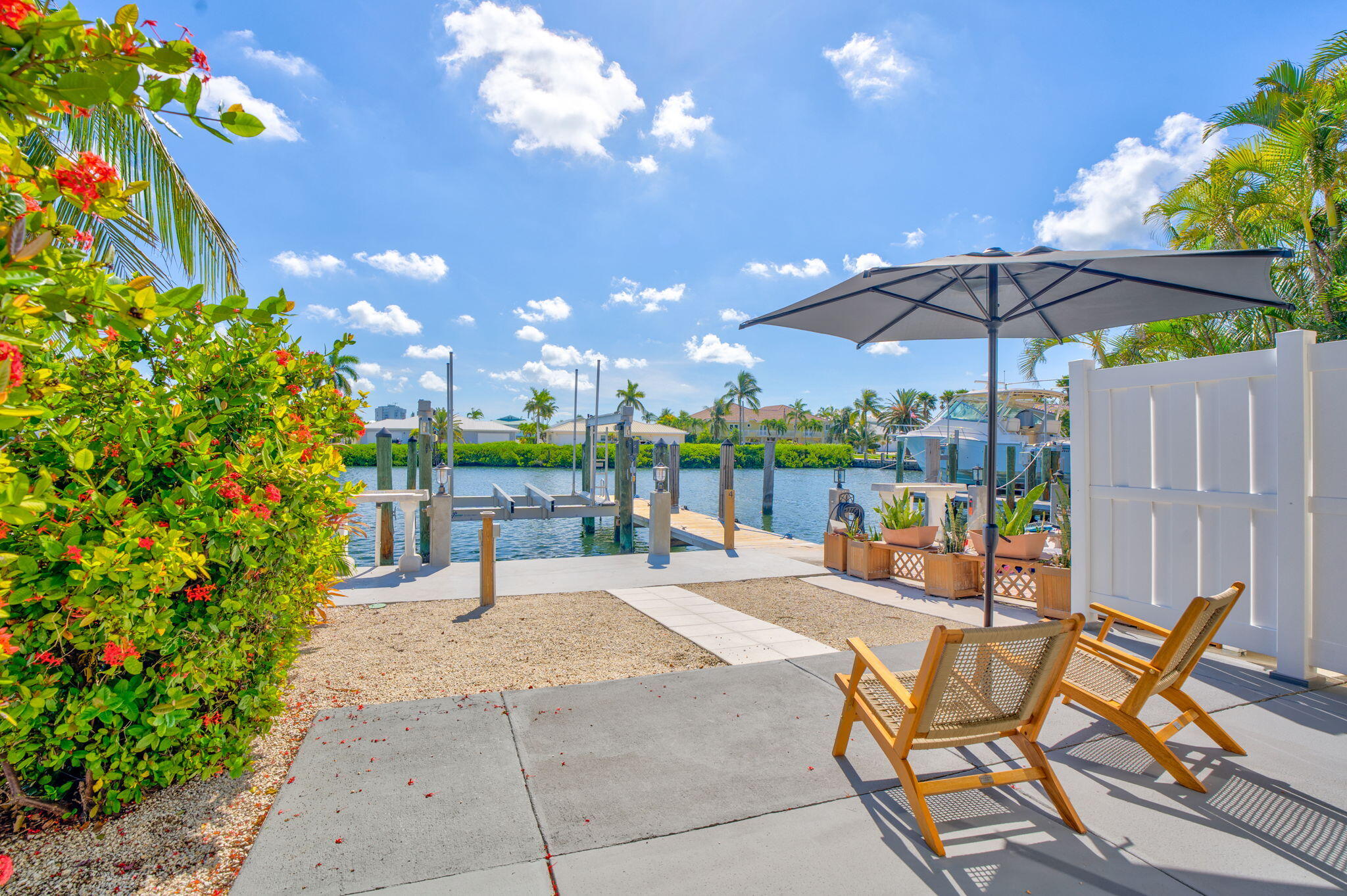 4 7th Street Key Colony Beach, FL 33051 - Photo 37 of 44 a view of a patio with a table and chairs under an umbrella with a small yard