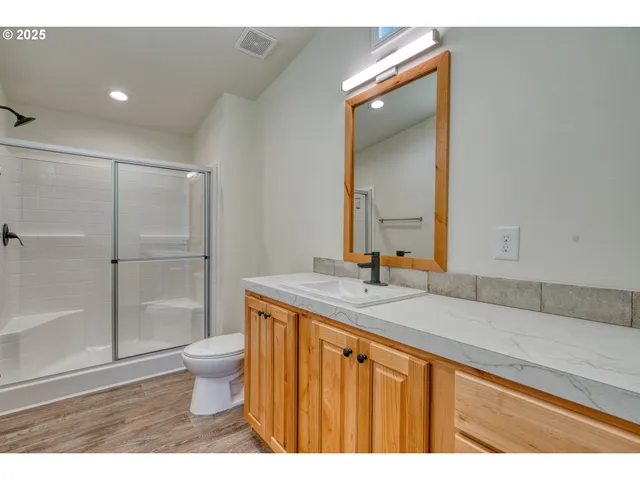 a bathroom with a granite countertop sink a toilet and a mirror