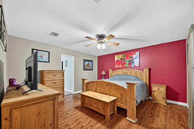 a bedroom with a large bed a chandelier and a window