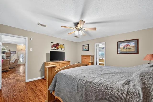 a bedroom with a bed and wooden floor