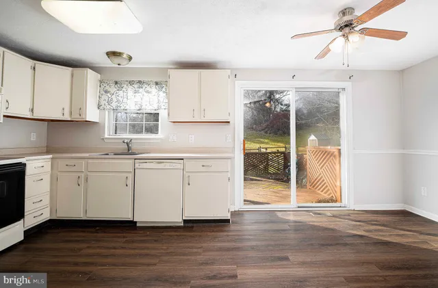a kitchen with granite countertop a sink window and cabinets