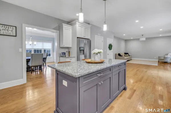 a large kitchen with kitchen island a large counter space a sink appliances and living room view