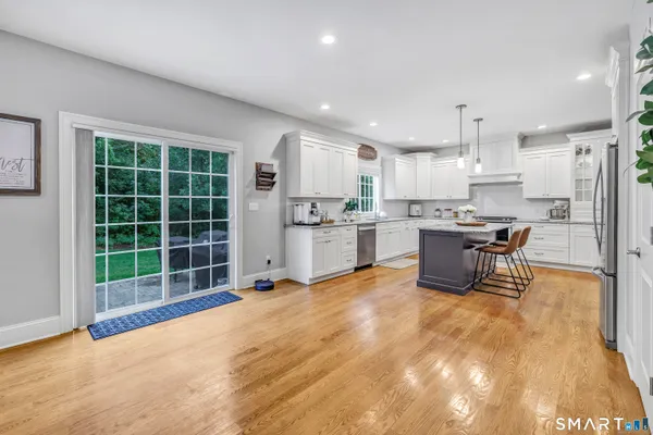 a view of a kitchen with stainless steel appliances wooden cabinets and dining table
