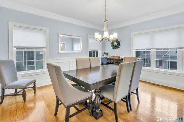 a view of a dining room with furniture a chandelier and wooden floor