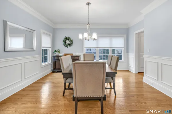 a dining room with furniture a chandelier and wooden floor