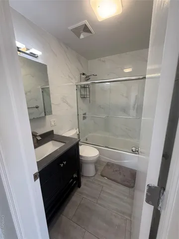 a bathroom with a double vanity sink toilet and shower