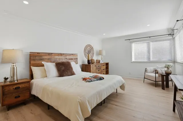 a bedroom with a bed and wooden floor