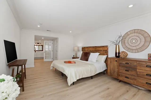 a bedroom with a bed and wooden floor
