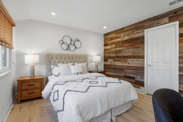 a bedroom with a bed and wooden floor