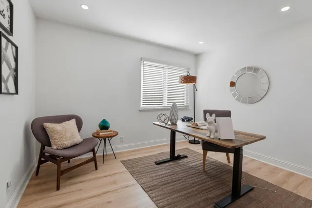 a view of a workspace room with wooden floor a table and chairs