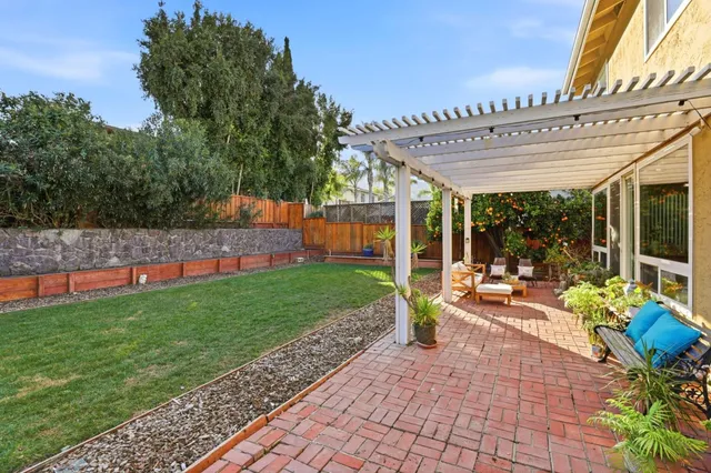 a view of a house with backyard and sitting area