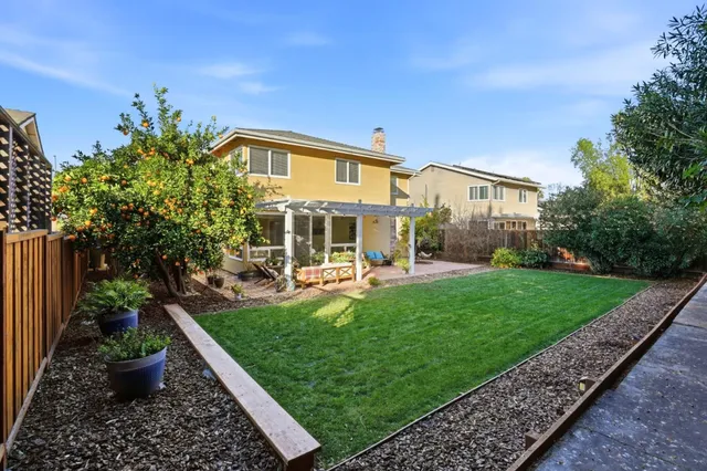 a view of a house with backyard sitting area and garden