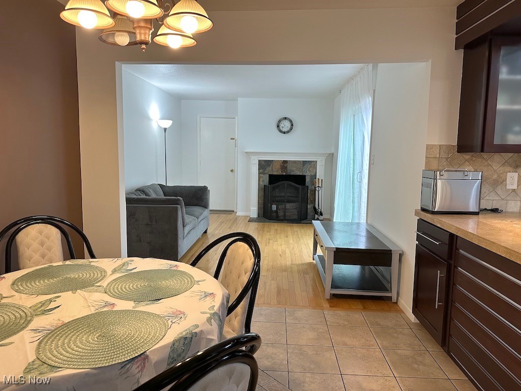 6482 State Road, Unit E1 Parma, OH 44134 - Photo 9 of 48 Dining room featuring a tiled fireplace, a chandelier, and light tile patterned floors