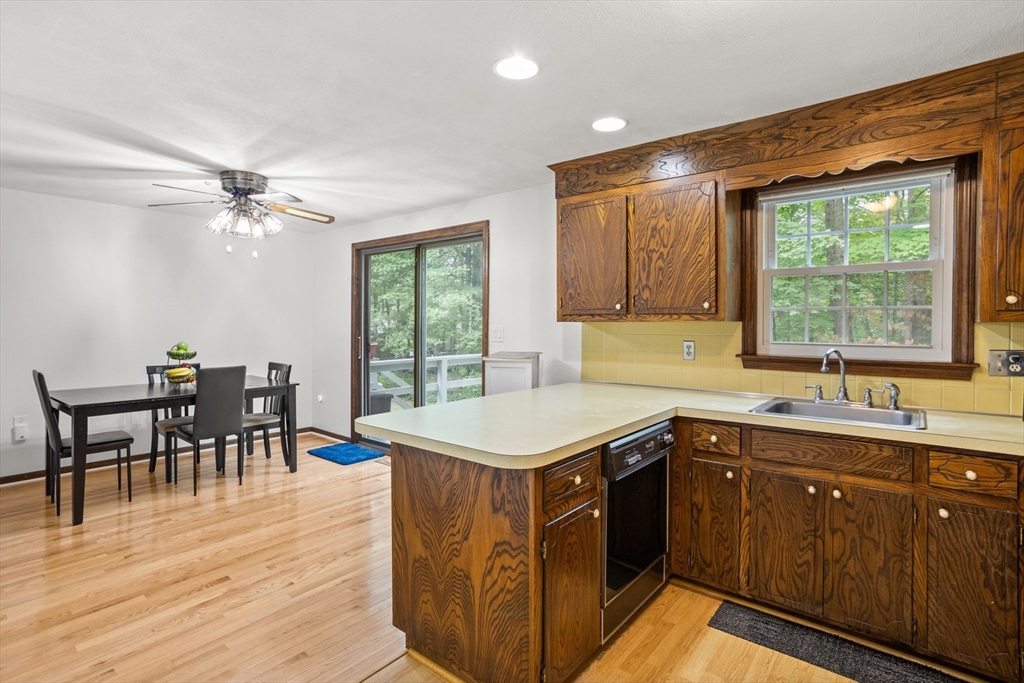 101 Drummer Road, Unit 101 Acton, MA 01720 - Photo 11 of 24 a kitchen with a stove a sink a dining table and chairs