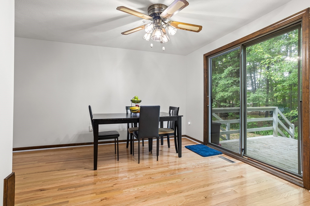 101 Drummer Road, Unit 101 Acton, MA 01720 - Photo 7 of 24 a view of a dining room with furniture a chandelier and wooden floor