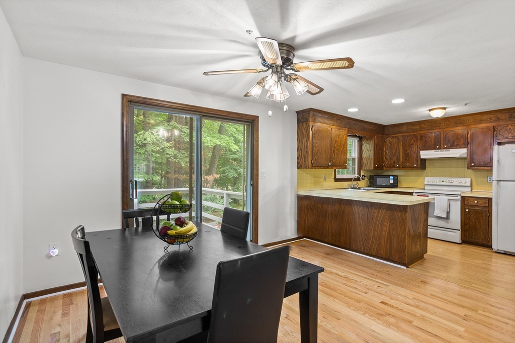 101 Drummer Road, Unit 101 Acton, MA 01720 - Photo 8 of 24 a kitchen with a table chairs microwave and cabinets
