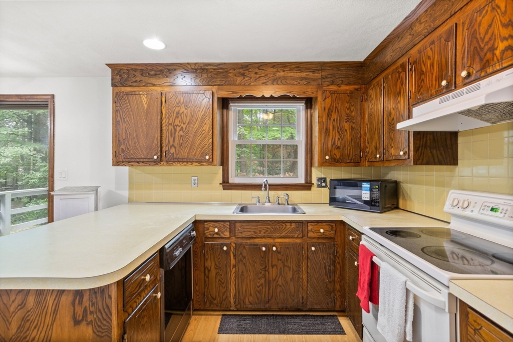 101 Drummer Road, Unit 101 Acton, MA 01720 - Photo 10 of 24 a kitchen with a sink a stove cabinets and a wooden floor